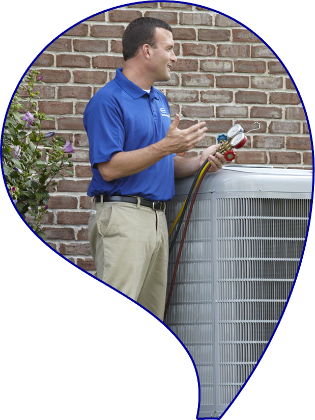 Technician in blue shirt using gauges on an outdoor HVAC unit, demonstrating heating and cooling service expertise for residential and commercial clients.