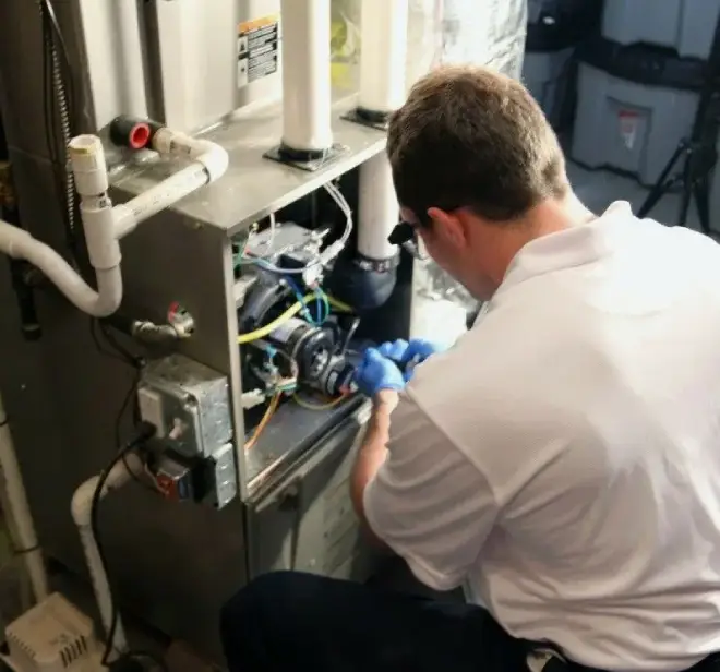 HVAC technician performing maintenance on a furnace, ensuring reliable heating service for homes in Lake Orion.