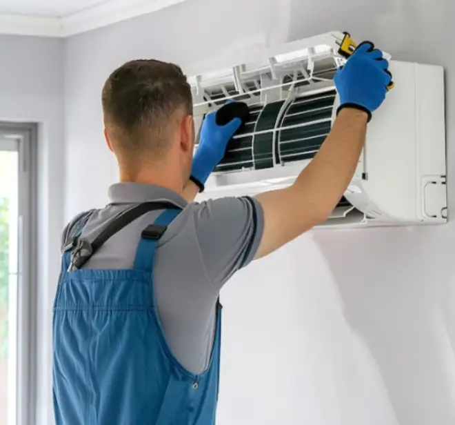 Technician servicing a ductless mini-split air conditioning unit, emphasizing HVAC maintenance and repair services for residential comfort.
