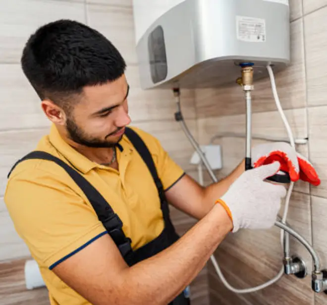 Technician installing an electric water heater, ensuring proper connections and safety measures in a residential setting.