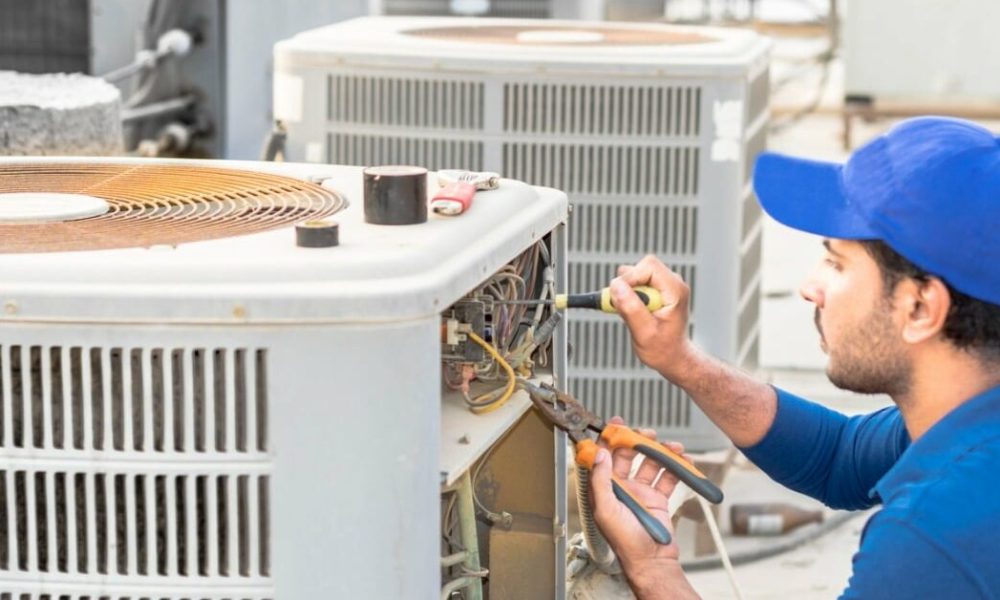 Technician repairing air conditioning unit, ensuring efficient HVAC service and maintenance for residential comfort.