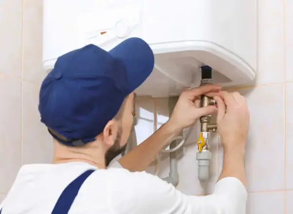 Licensed plumber installing a gas water heater, focusing on safety and compliance, highlighting professional service by Comfort Plus.