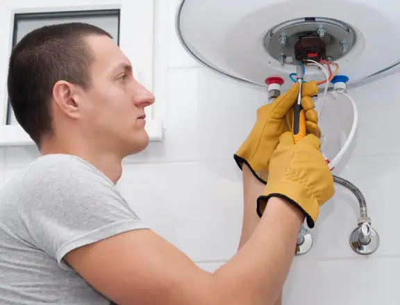 Technician in gloves installing a water heater, demonstrating professional installation services by Comfort Plus for reliable hot water supply.