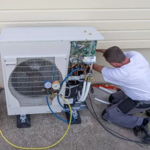 HVAC contractor repairing residential air conditioning unit to improve efficiency and reduce energy bills in Troy MI