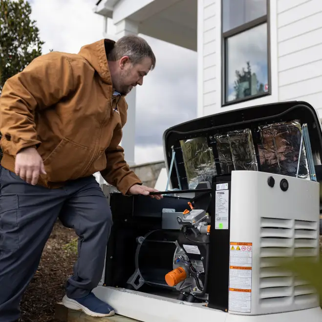 Technician inspecting home generator system installation outside residential property, ensuring reliable backup power for homeowners.