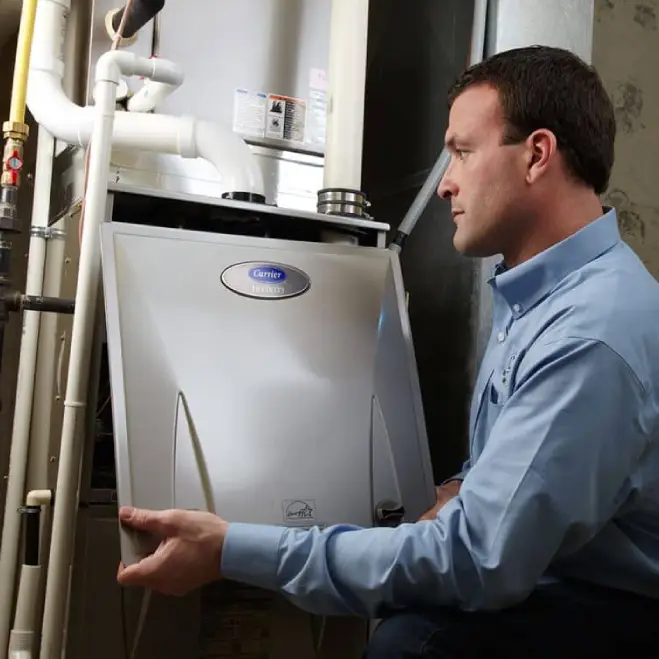 Technician inspecting a Carrier furnace, performing maintenance to ensure efficient heating system operation in a residential setting.