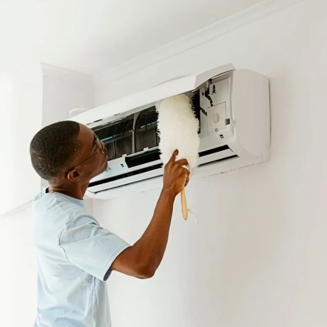 Technician cleaning a mini-split air conditioning unit, ensuring efficient cooling and maintenance for HVAC systems.