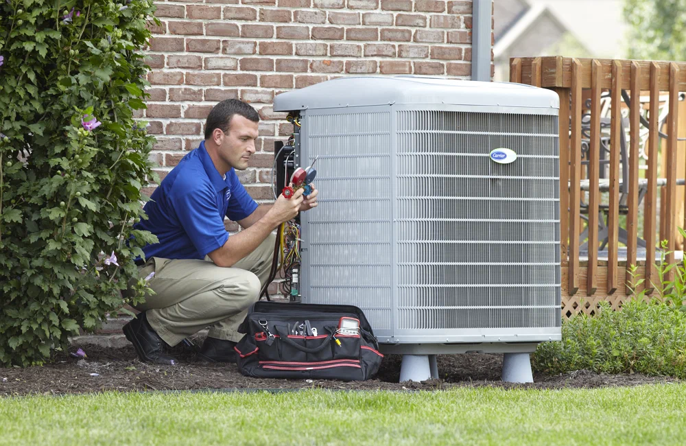 HVAC technician performing maintenance on air conditioning unit outside a home, emphasizing professional repair services and system efficiency.