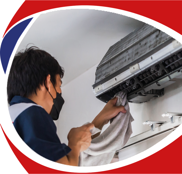 Technician performing air conditioning maintenance by cleaning an AC unit indoors, emphasizing professional HVAC services for comfort and efficiency.