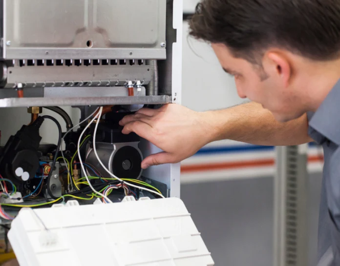 Technician inspecting heating system components, focusing on maintenance and repair for efficient HVAC performance.